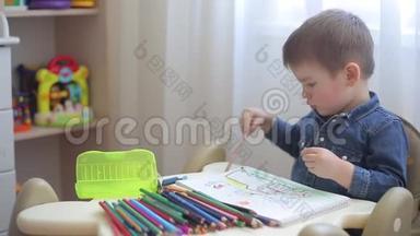 一个小孩子学会用彩色铅笔在纸上画画